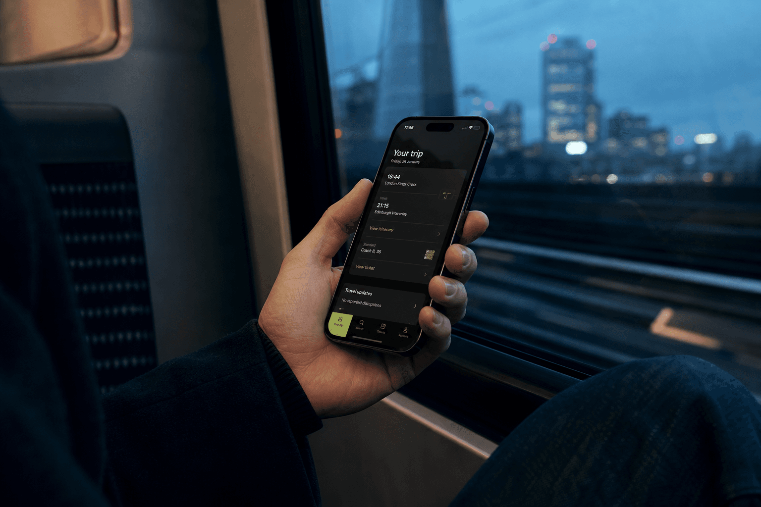 Passenger using a mobile service application during an evening train journey